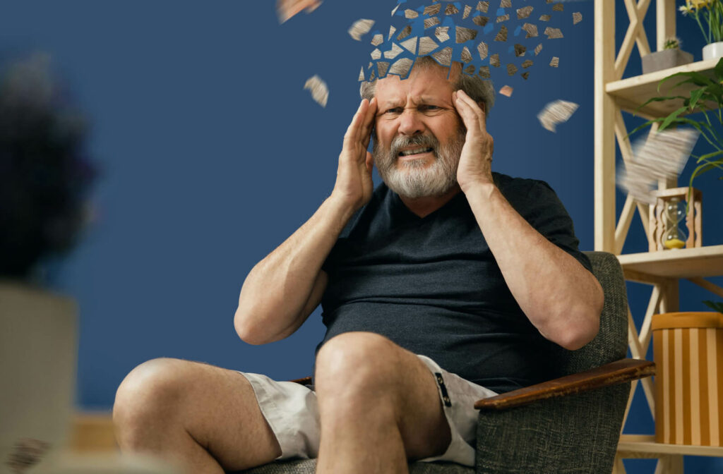 An older man with his head fracturing as a visual representation of grappling with depression, frustration, and helplessness caused by dementia